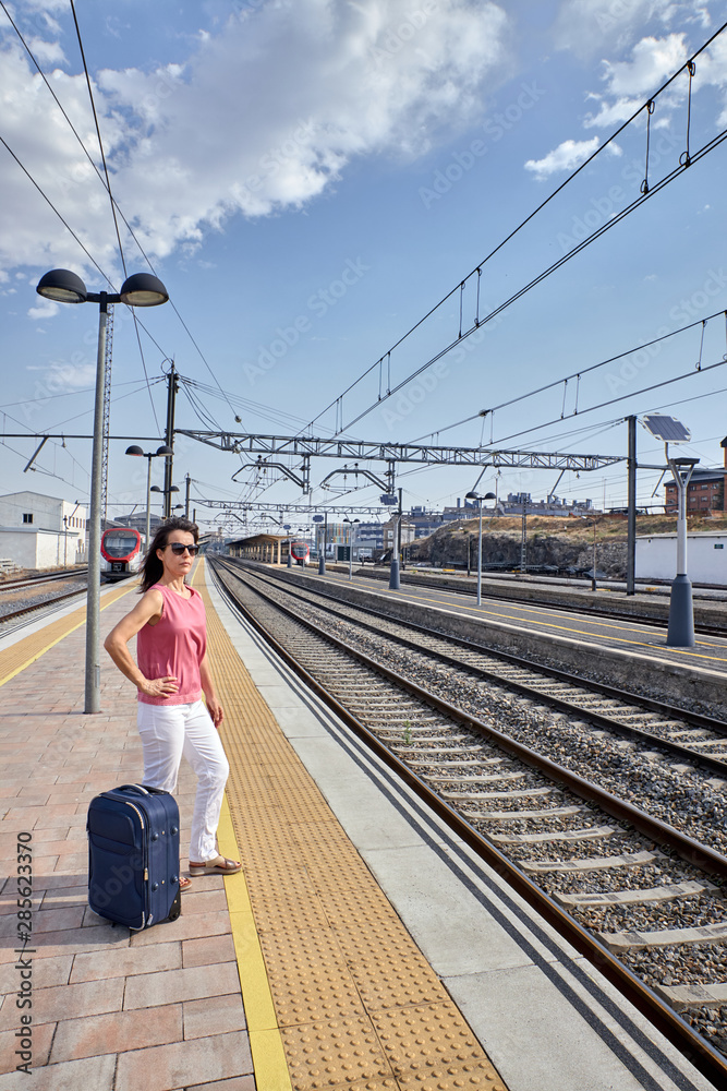 woman waiting for the train with a suitcase