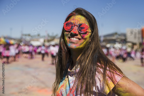 Holi color on woman's face looking at camera