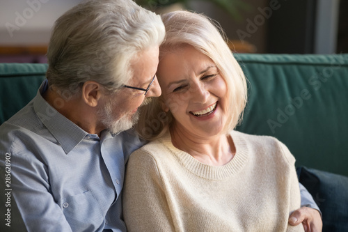 Happy senior old couple bonding talking embracing laughing at home