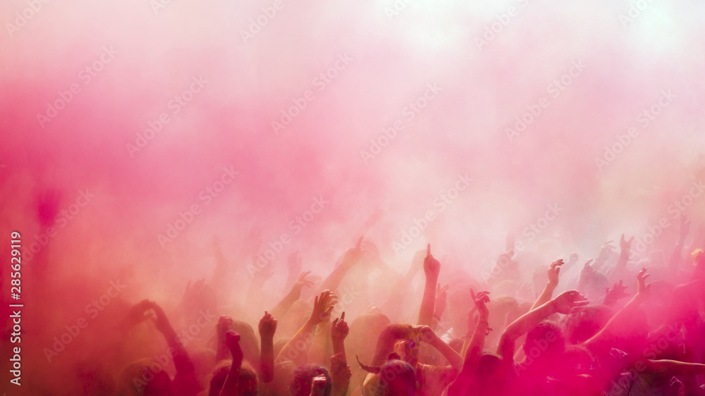 Red and pink holi colors over the crowd - obrazy, fototapety, plakaty 
