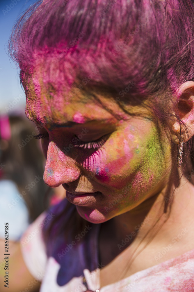 Close-up of a woman's face covered with holi color