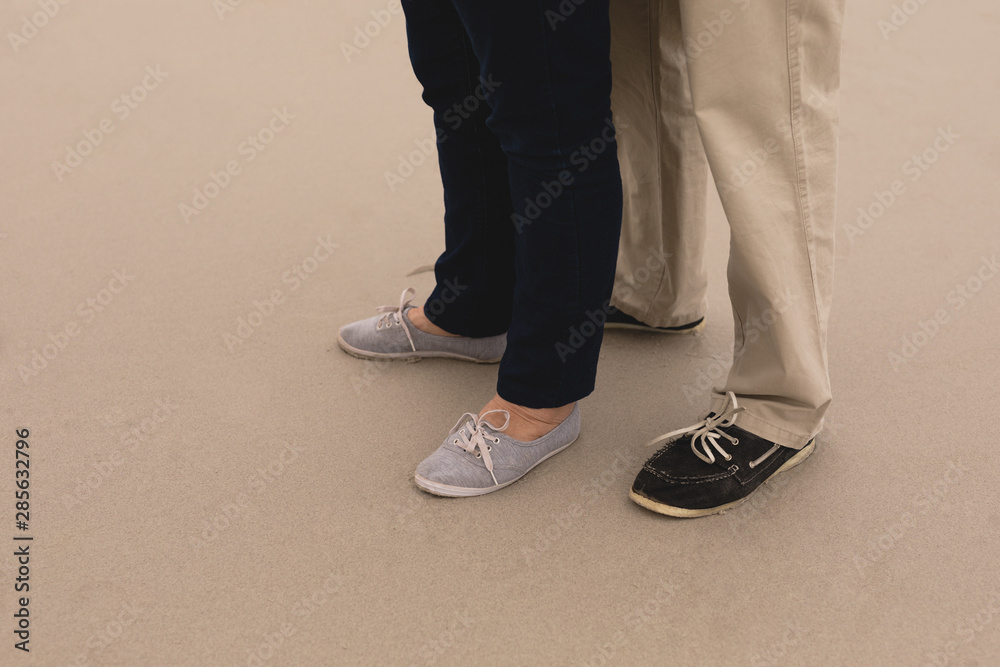 Feet of senior couple standing at the beach Feet of senior couple standing at the beach