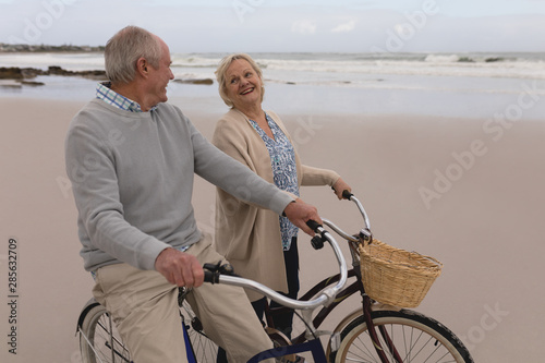 Senior couple interacting with each other while riding bicycle 