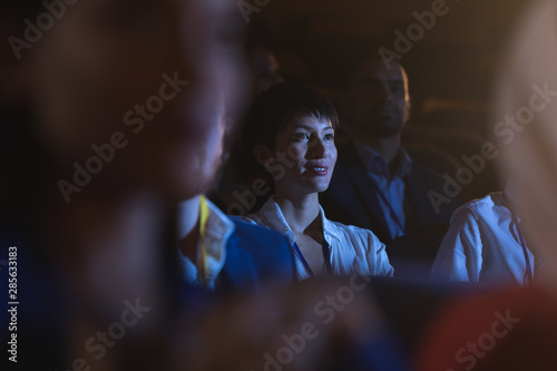 Businesswoman sitting and listening to the presentation with audience