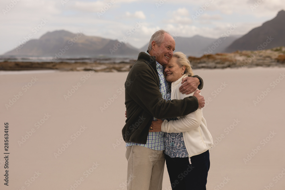 Senior couple embracing standing at the beach 