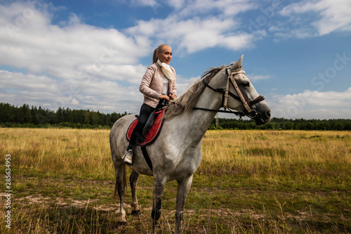 woman riding horse in field