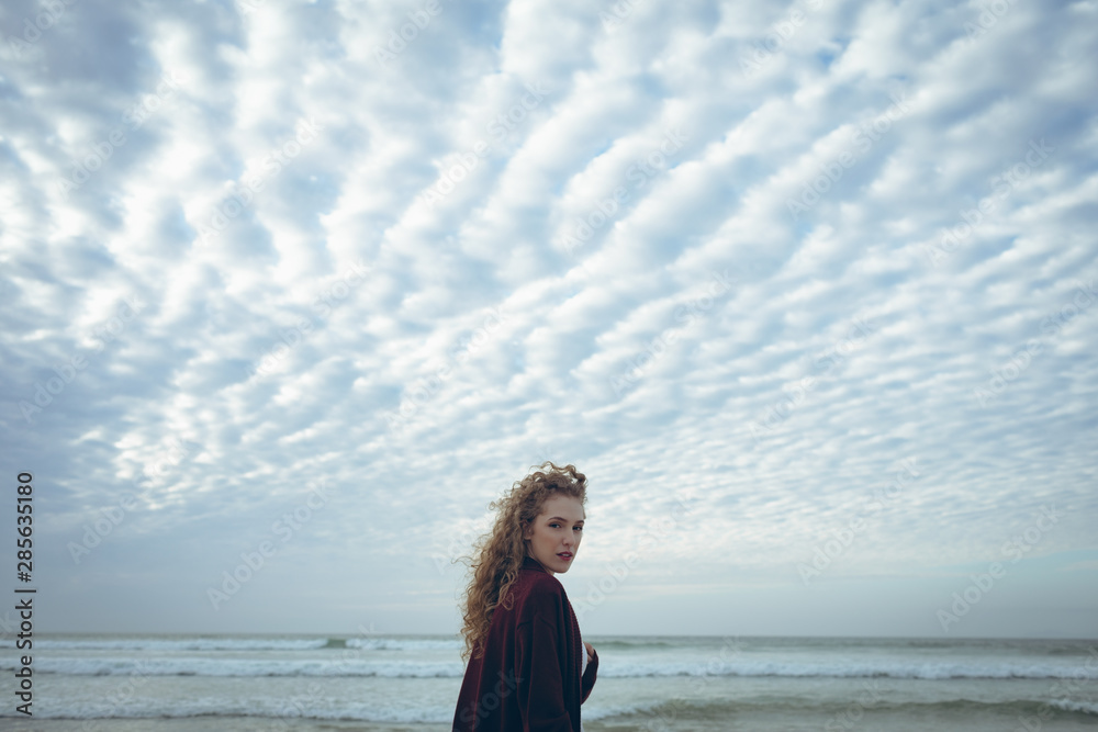 Beautiful woman looking at camera standing at beach Beautiful woman looking at camera standing at beach
