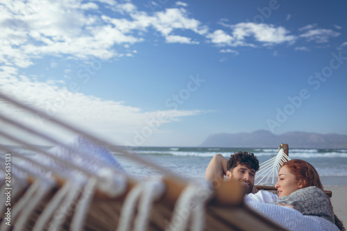 Couple interacting with each other while relaxing at hammock