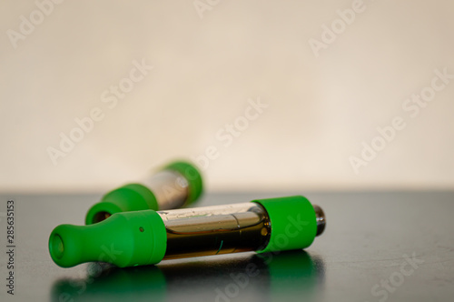 Close up of two marijuana THC CBD oil cartridges for vaping.