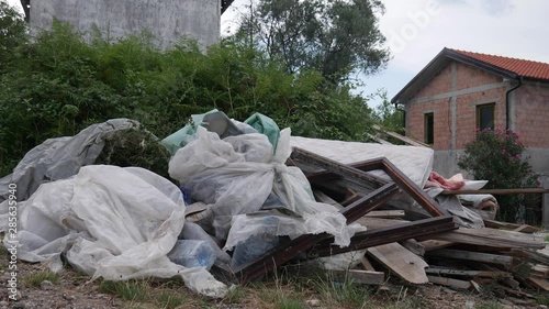 Garbage dumped: boards, mattress, comforter, plastic bags full of garbage