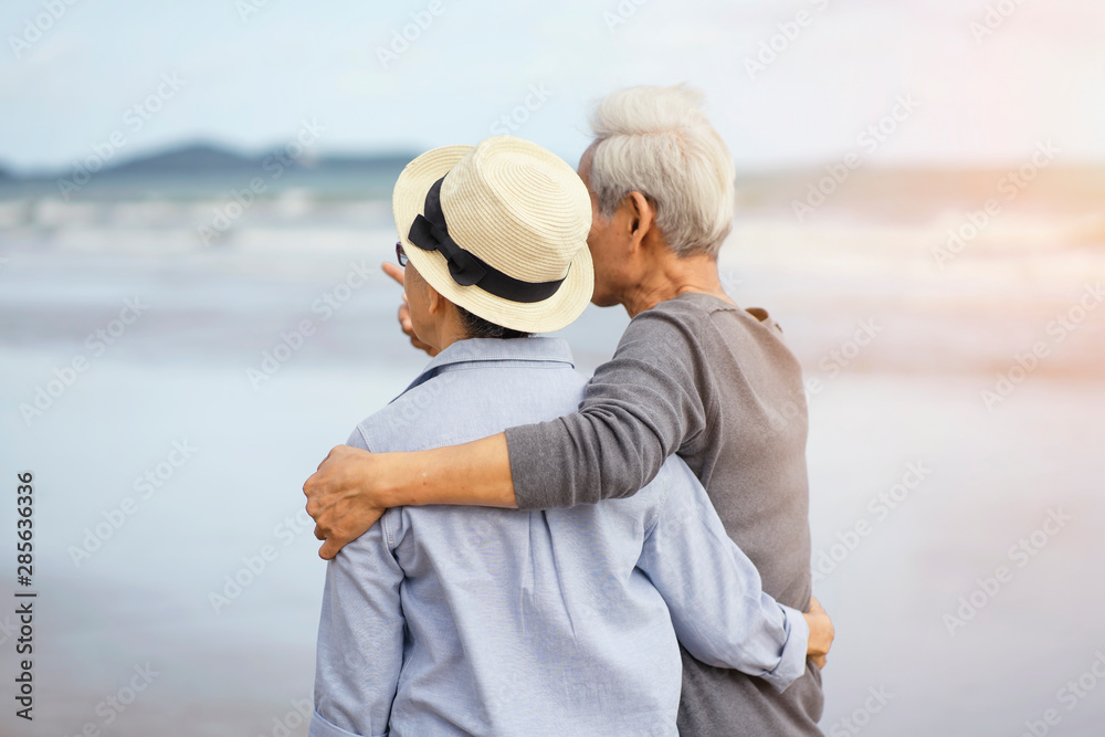 Life after retirement.Elderly life insurance.The old couple side by side until the old man.The elderly couple walk hand in hand on the beach to relax after long work.