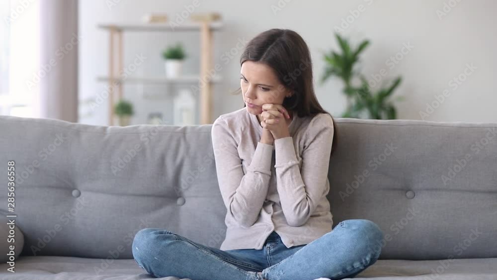 Woman sitting on couch feels nervous caused by personal problems Woman sitting on couch feels nervous caused by personal problems