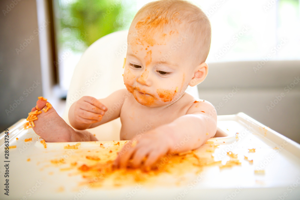 Little baby boy eating her dinner and making a mess Stock Photo