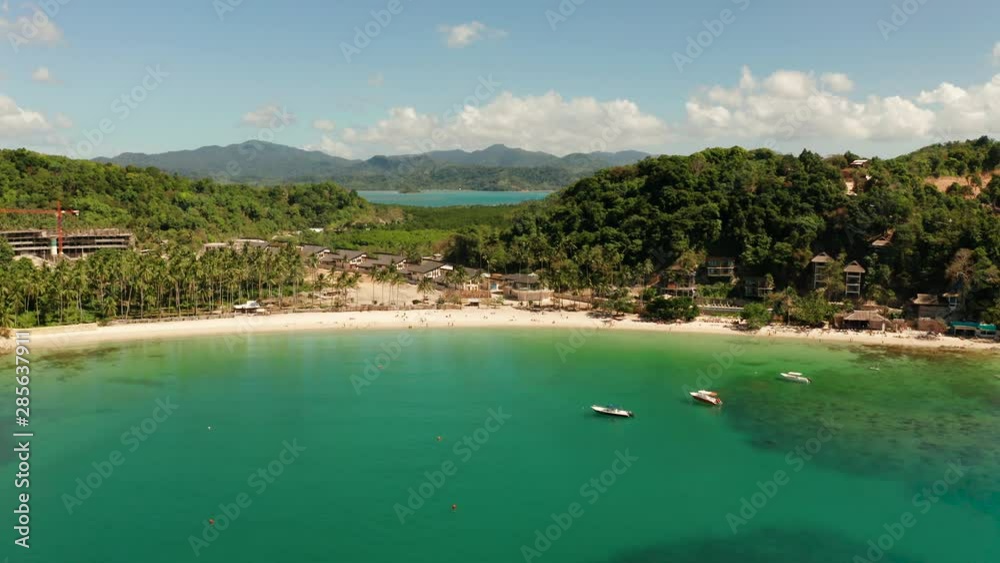 Aerial view tropical sandy beach and blue water. Las Cabanas, El Nido, Palawan, Philippines. Seascape with sea, sand, palm trees. Summer and travel vacation concept Aerial view tropical sandy beach and blue water. Las Cabanas, El Nido, Palawan, Philippines. Seascape with sea, sand, palm trees. Summer and travel vacation concept