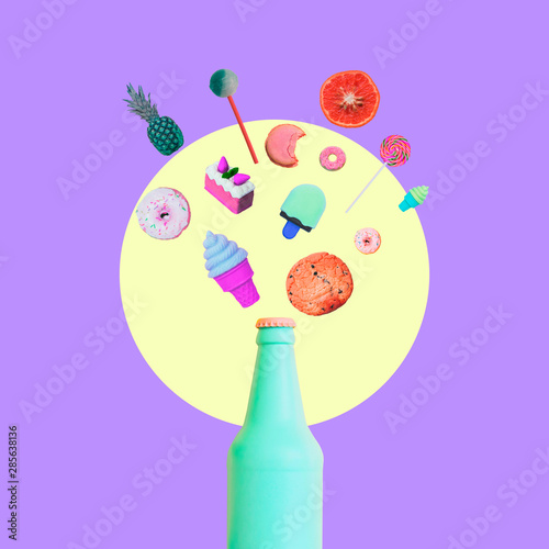Fototapeta A piece of cake, ice cream, candy, cookies, pineapple, orange and other sweets are pulled from a colored bottle of beer or champagne. Concept of a holiday or celebration of a party