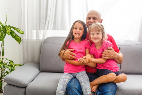 grandfather and granddaughters at home