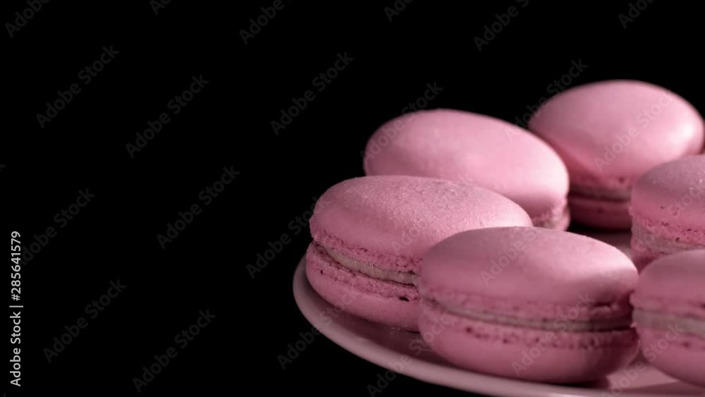 Macaroons rotating on table close-up. Cake macaroon on black background. Macaroon cookies slow rotates. Macaroons rotating on table close-up. Cake macaroon on black background. Macaroon cookies slow rotates.