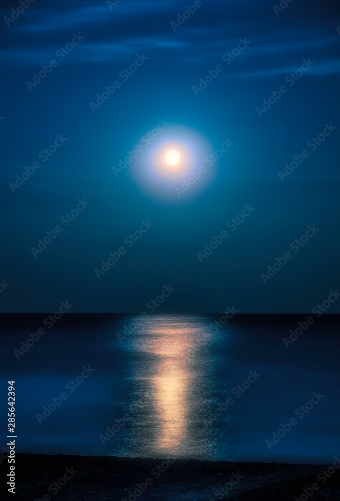 Moonlit night over the sea. Full moon and lunar pathover the sea. Full moon and lunar path