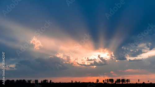 rays sunset through rain clouds. Epic landscape photography.
