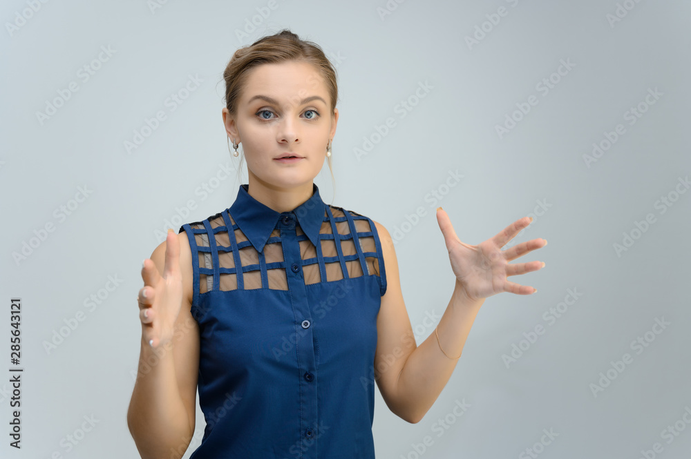 Studio photo a waist-high portrait of a pretty young woman girl in a business suit on a white background. He stands right in front of the camera, explains, with emotion. Studio photo a waist-high portrait of a pretty young woman girl in a business suit on a white background. He stands right in front of the camera, explains, with emotion.