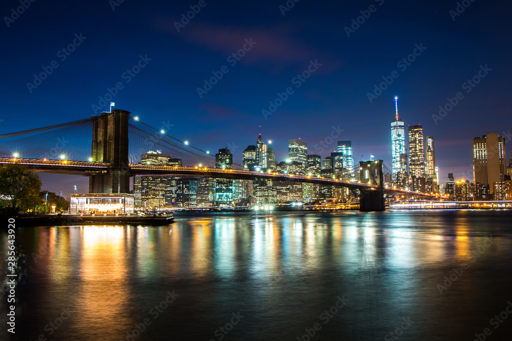Brooklyn Bridge at night with One World Trade Center and Manhattan in the background