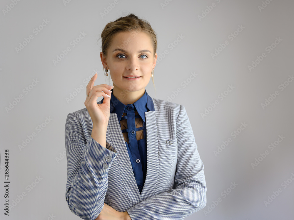 Studio photo a waist-high portrait of a pretty young woman girl in a business suit on a white background. He stands right in front of the camera, explains, with emotion. Studio photo a waist-high portrait of a pretty young woman girl in a business suit on a white background. He stands right in front of the camera, explains, with emotion.