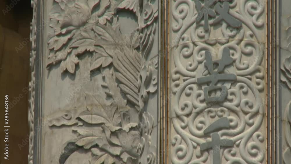 Extreme close-up low-angle tilting shot of artistic carvings and writings on a pillar wall next to Goddess of Mercy statue, Kek Lok Si Temple, Penang, Malaysia Extreme close-up low-angle tilting shot of artistic carvings and writings on a pillar wall next to Goddess of Mercy statue, Kek Lok Si Temple, Penang, Malaysia