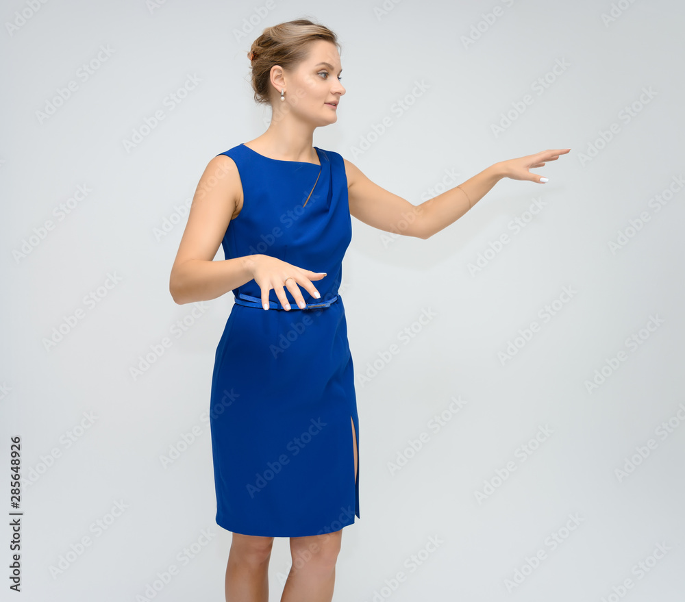 Full length studio portrait photo of a cute young woman girl in a beautiful blue dress on a white background. He stands right in front of the camera, explains with emotion. Full length studio portrait photo of a cute young woman girl in a beautiful blue dress on a white background. He stands right in front of the camera, explains with emotion.