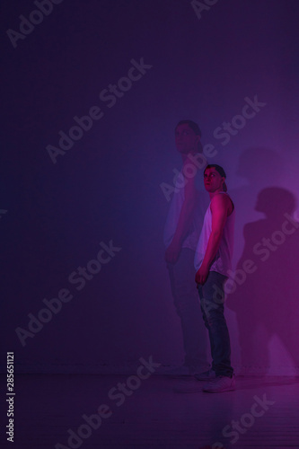 Guy is a hip hop dancer in a Studio with colored light. Double exposure photo