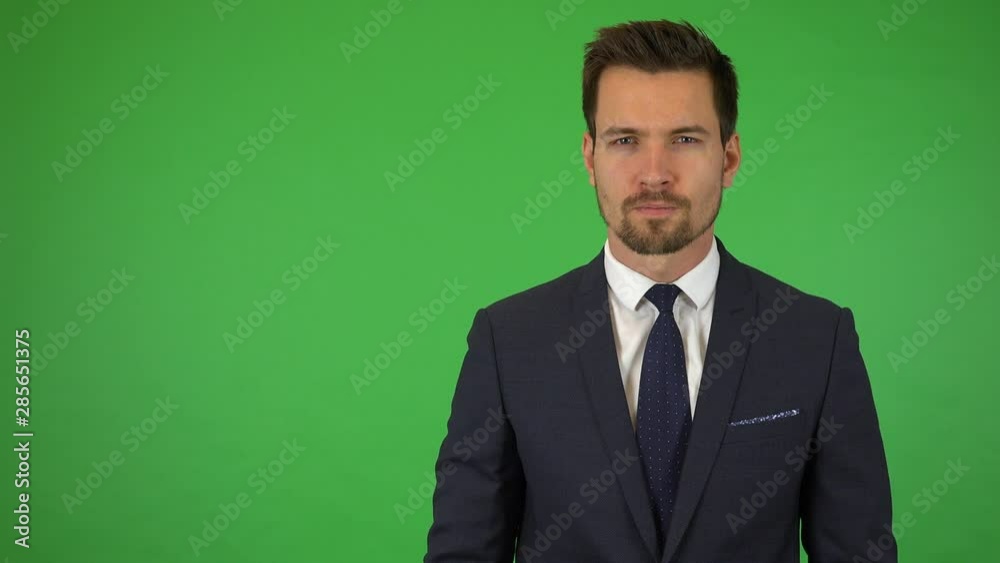 A young handsome businessman looks seriously at the camera - green screen studio A young handsome businessman looks seriously at the camera - green screen studio