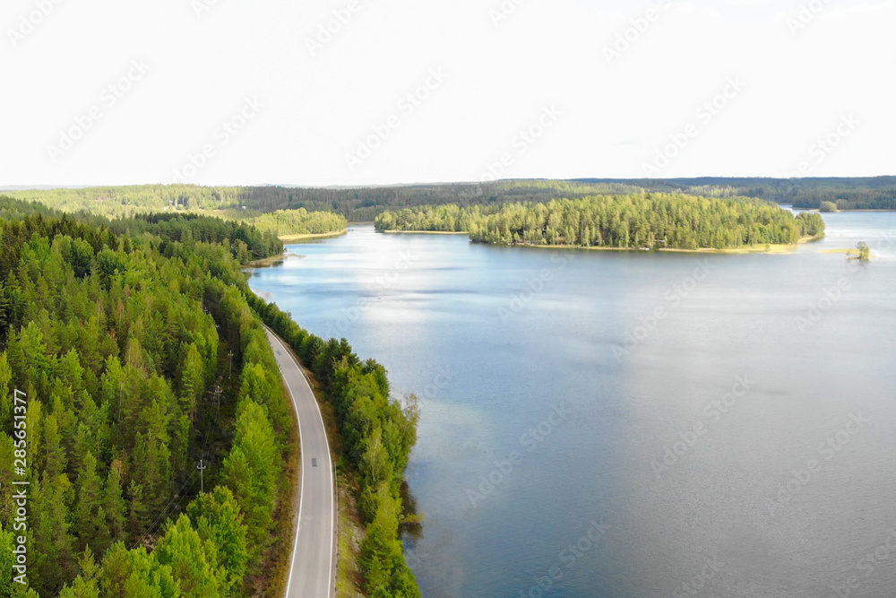 Aerial view of lake with island, road and forest on a summer sunny day in Finland. Drone photography Aerial view of lake with island, road and forest on a summer sunny day in Finland. Drone photography