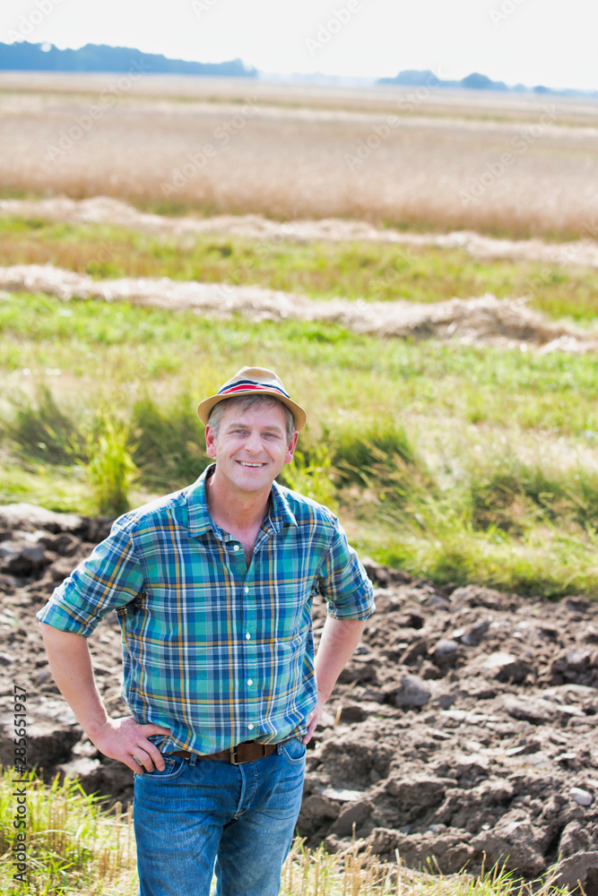 Fototapeta premium Portrait of Happy mature farmer standing in field