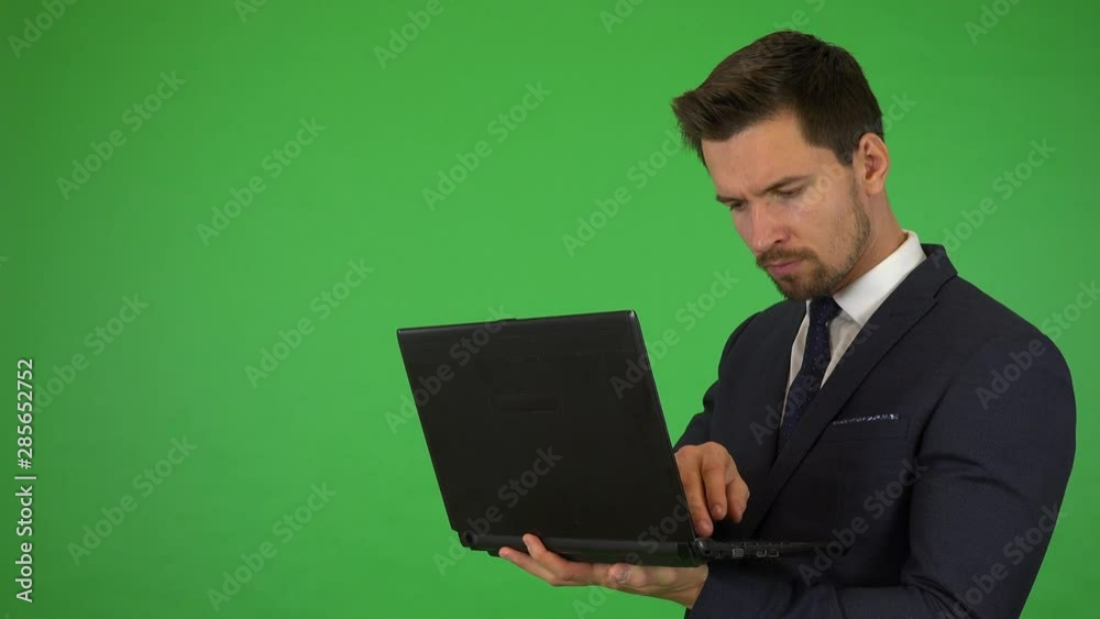 A young handsome businessman works on a notebook - green screen studio A young handsome businessman works on a notebook - green screen studio