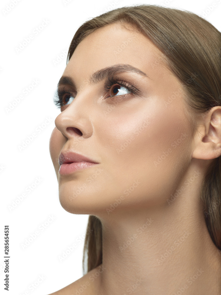 Portrait of beautiful young woman isolated on white studio background. Caucasian female model looking at side and posing. Concept of women's health and beauty, self-care, body and skin care. Portrait of beautiful young woman isolated on white studio background. Caucasian female model looking at side and posing. Concept of women's health and beauty, self-care, body and skin care.
