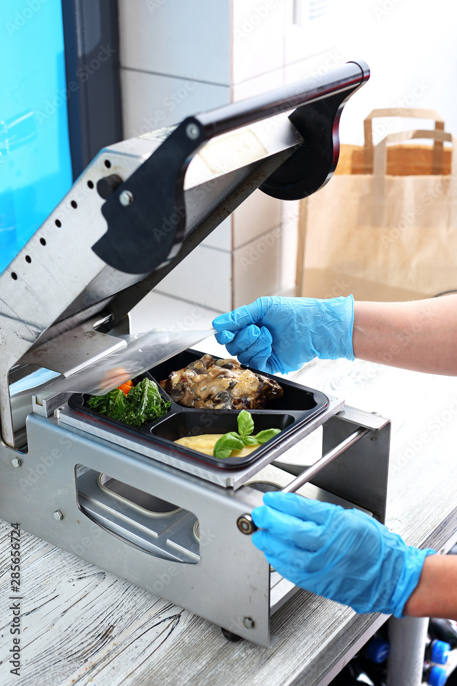 Vacuum take-out food packaging. The dish is packed in a restaurant. Vacuum take-out food packaging. The dish is packed in a restaurant.