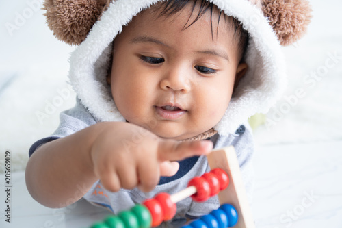 cute little asin baby boy playing with wooden toy photo