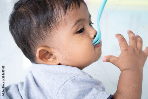 Cute little asin baby boy with spoon photo