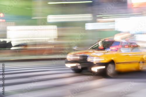 Speed motion abstract blurred of taxi with neon urban night light at shinjuku road in tokyo japan with billboard background