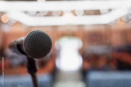 Microphone on abstract blurred conference hall prepare for speaker on stage in seminar room. lecture to audience university with bokeh background. Business meeting or education teaching image photo