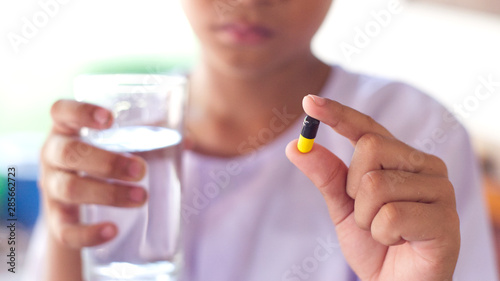 Close up of child taking a pills.