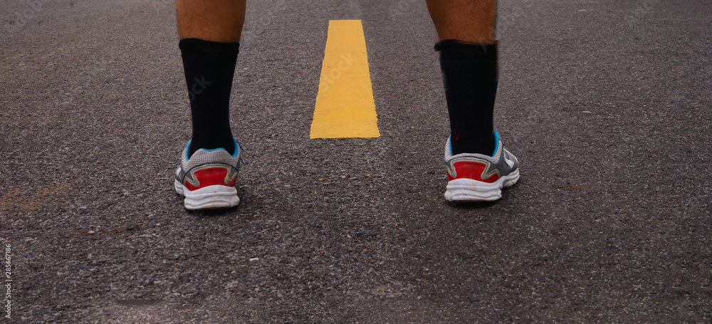 Close up of man with shoe on road.Concept of start. Close up of man with shoe on road.Concept of start.