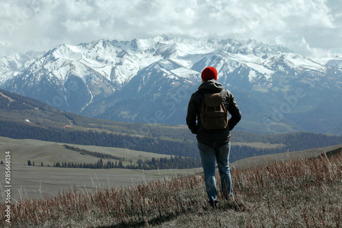 Hipster in red beanie looking at the mountains © kuzovkov