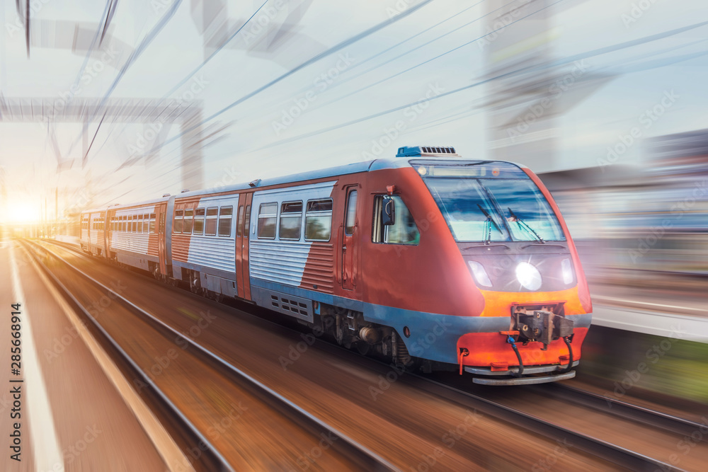 Obraz premium Pociąg pasażerski jedzie z efektem rozmycia ruchu kolejowego.