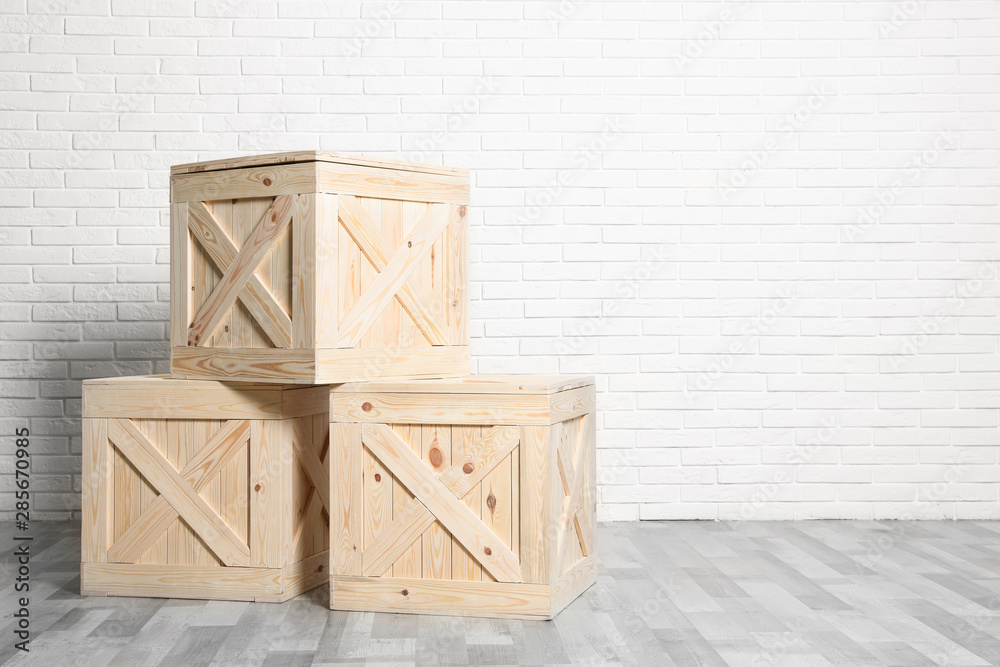 Wooden crates on floor at white brick wall. Space for text Wooden crates on floor at white brick wall. Space for text