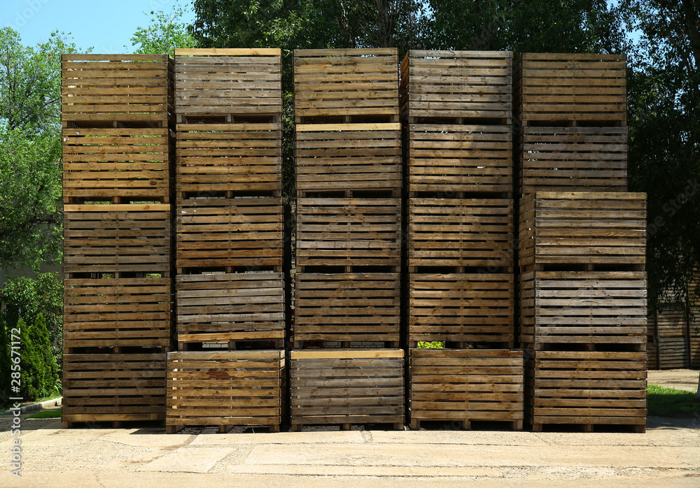 Pile of empty wooden crates at warehouse backyard on sunny day