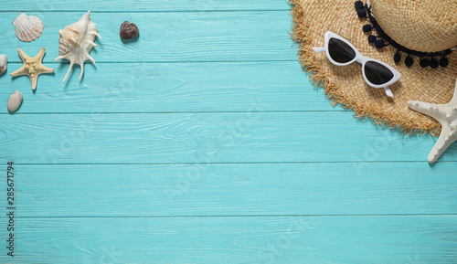 Flat lay composition with stylish beach accessories on light blue wooden background, space for text