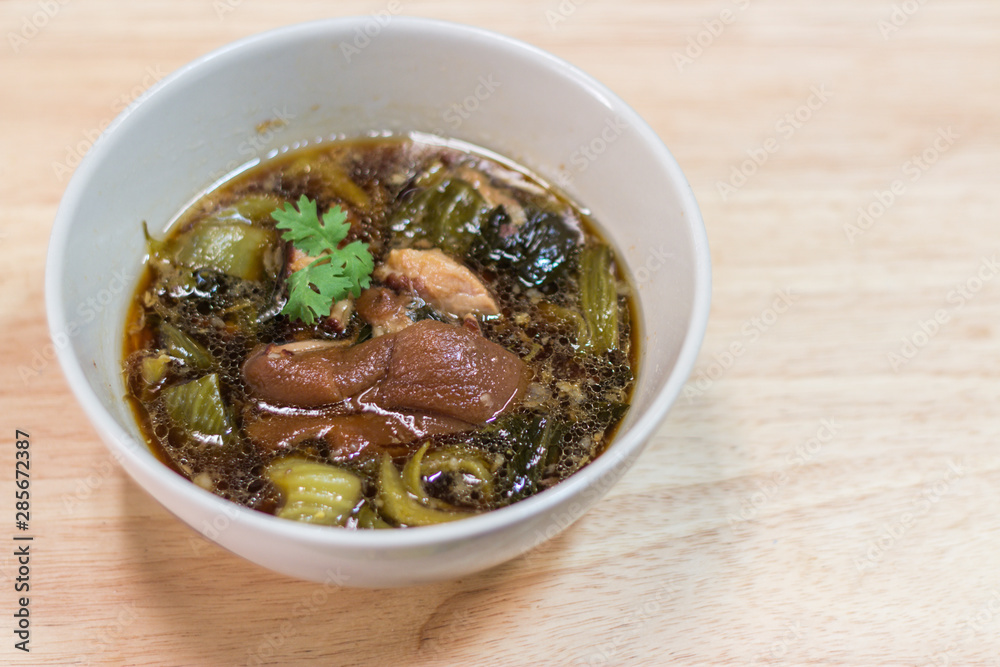 Pork brown pork leg in large plate with green pickled vegetables as side dishes in Thai restaurants Pork brown pork leg in large plate with green pickled vegetables as side dishes in Thai restaurants
