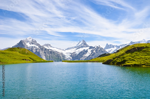 Beautiful Bachalpsee in the Swiss Alps photographed with famous mountain peaks Eiger, Jungfrau, and Monch. Lake and Alpine landscape. Switzerland in late summer. Snow-capped mountains, mountain range