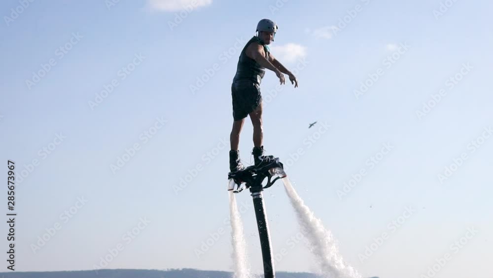 Flyboarding is a new extreme water sport. Athletic man performs tricks in flight. Spectacular sports coups and turns. Flyboarding is a new extreme water sport. Athletic man performs tricks in flight. Spectacular sports coups and turns.