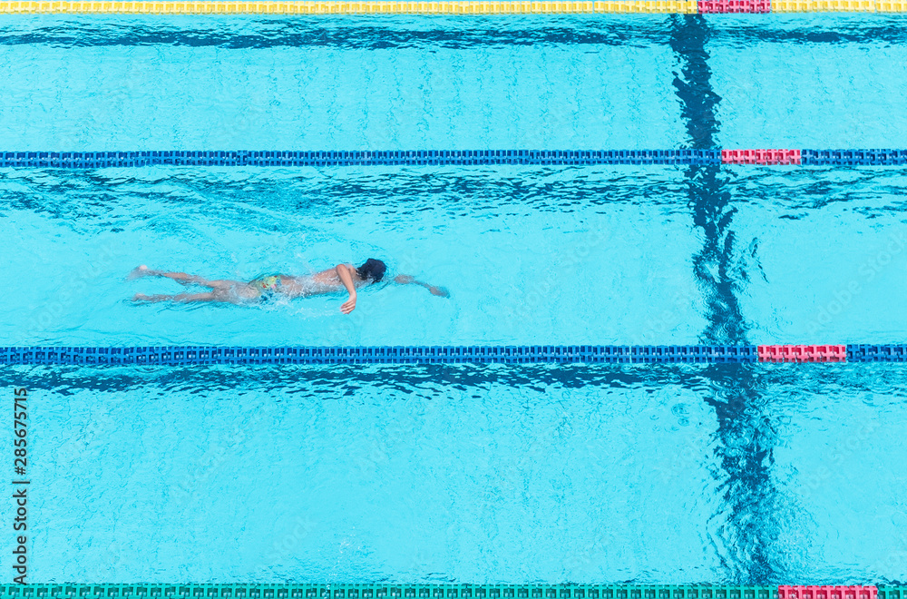 Top view shot of sportswoman swimming freestyle in a race